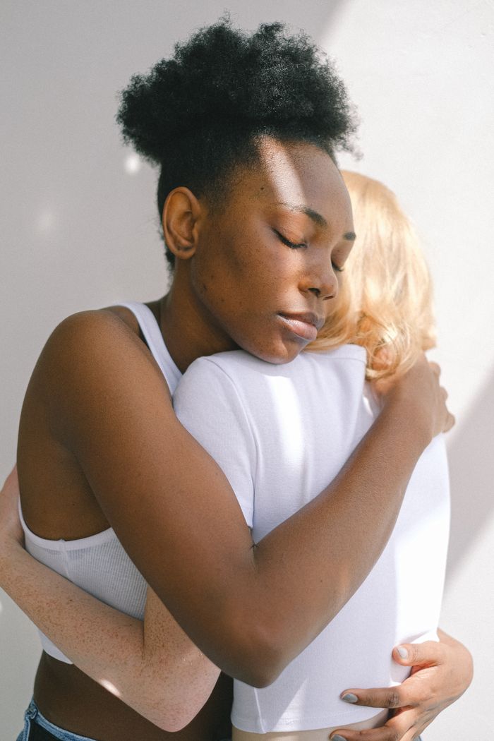 A heartfelt embrace between two women sharing an intimate, loving moment.