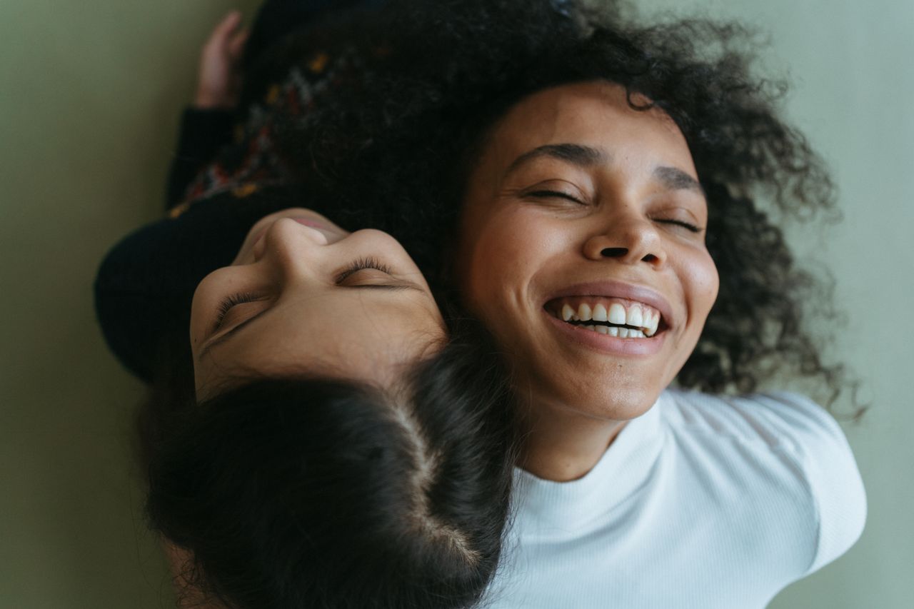 Happy mother and daughter sharing a joyful embrace, exuding warmth and love.